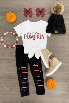 CARDIGAN SOLD SEPARATELY! *Please refer to size chart for the best fit* Top features short sleeves & a sweet pumpkin saying on the front Pants feature faux distressing & adjustable waistband Ultra-soft material for comfort & ease Perfect for Fall wear Bring on fall with this "Hello Pumpkin" Legging Set. This girls' set is styled with a white short sleeve tie top that features "Hello Pumpkin" embossed on the front and looks adorable paired with the matching leggings. The stretch waistband provides a secure fit and allows for all day comfort, while the faux distressed details add a fun touch. She can pair this set with booties or our fun bows for the perfect fall look! bullets:Includes: Top & Bottoms 97% Cotton, 3% Spandex Pumpkin Leggings, Sparkle In Pink, Cute Girl Outfits, Sweet Pumpkin, Kids Couture, Matching Leggings, Fall Wear, Tie Top, Cute Fall Outfits