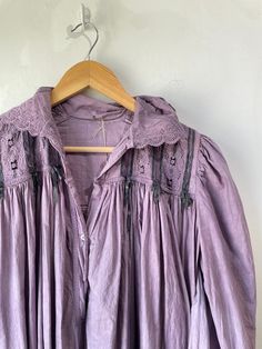 Vintage Victorian Overdyed Purple Dress. Lace-trimmed dress with bow details and puffy sleeves that make you feel like you're in a haunted 1920s mansion. The collar has black details that bring out the lacey designs. In good vintage condition with a few missing buttons (sold as is). Fits like a S/M. Feels like cotton/linen. Approx. Measurements: Underarm to underarm: 18" Length: 55" Cottagecore Victorian Dress With Lace Trim And Long Sleeves, Vintage Fitted Ruffle Nightgown, Vintage Fitted Nightgown With Ruffles, Fitted Vintage Nightgown With Ruffles, Peasant Style Victorian Dress For Daywear, Vintage Victorian Dress With Lace Collar And Long Sleeves, Long Sleeve Victorian Cottagecore Dress, Vintage Lace Trim Dresses For Loungewear, Vintage Dresses For Spring Night