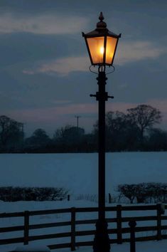 a street light in the middle of a snowy field