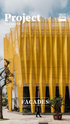 a person walking past a yellow building on the cover of project new zealand's facades