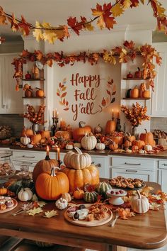 a wooden table topped with lots of pumpkins and other autumn decorations on top of it