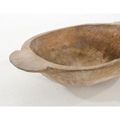 an old wooden bowl sitting on top of a white table