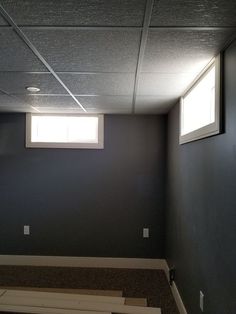 an empty room with two windows and no one on the floor in front of it