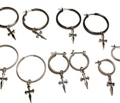 six pairs of hoop earrings with cross charms on each side and one earring in the middle