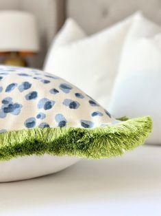 a close up of a pillow on a bed with white pillows and blue polka dots