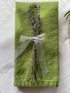 a green napkin with some lavender flowers tied to it