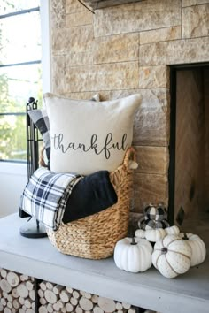 a fireplace with some pumpkins and a pillow on it