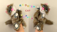 a hand holding a stuffed animal with the words redfish cat puppett on it