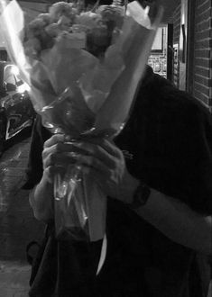 a man holding a bunch of flowers in his hands