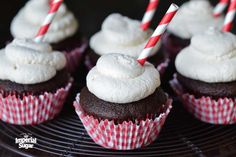 chocolate cupcakes with white frosting and candy canes