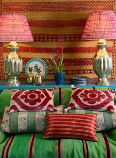 a bed with two lamps on top of it next to some pillows and other decorative items