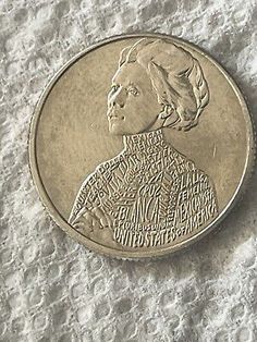 a coin with the face of a woman in profile on top of snow covered ground