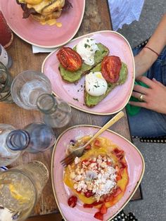 three plates with different types of food on them sitting on top of a wooden table