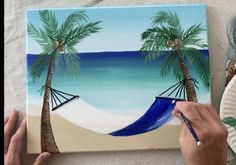 someone is painting a beach scene with palm trees