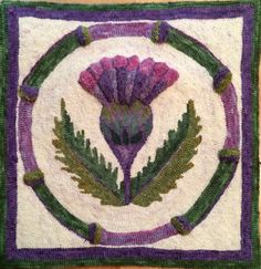 a close up of a rug on a wooden floor with flowers and leaves in the center