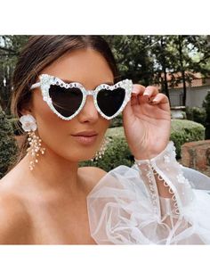 a woman wearing heart shaped sunglasses with pearls