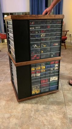 a man standing next to a large display case filled with lots of legos and boxes