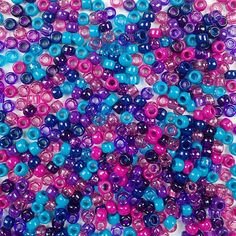 many different colored beads on a white surface with pink, blue and purple dots in the middle