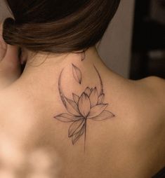 a woman with a lotus tattoo on her back neck and behind the neck is a crescent moon