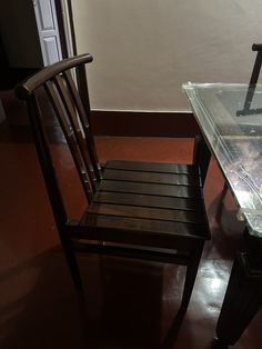 a wooden chair sitting next to a glass table