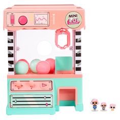 a pink and green toy cash register machine next to three small dolls on a white background