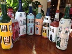 a group of painted bottles sitting on top of a wooden table