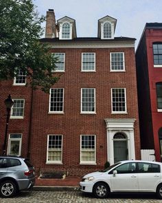 two cars parked in front of a brick building