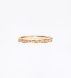 a yellow gold band with small diamonds on the inside and outside, set against a white background