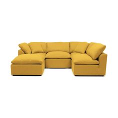 a yellow sectional couch with pillows on it's back and side ends, facing away from the camera