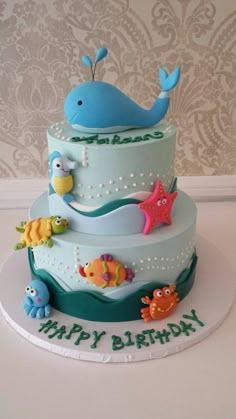 a three tiered birthday cake with an ocean theme