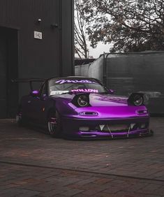 a purple car parked in front of a building