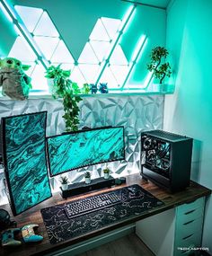 two computer monitors sitting on top of a wooden desk