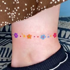 a woman's ankle with colorful flowers painted on it