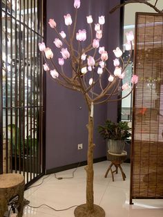 a lamp that is on top of a tree in the middle of a room with purple walls