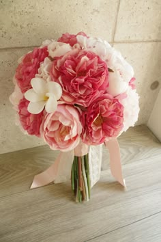 a bouquet of pink and white flowers sitting on top of a table