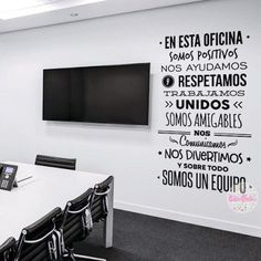 a conference room with white walls and black chairs in front of a flat screen tv mounted on the wall