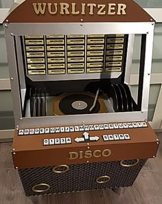 an old fashioned record player sitting on top of a hard wood floor next to a wall