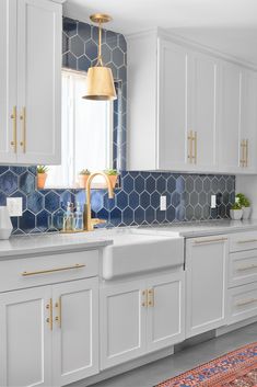 a kitchen with white cabinets and blue tiles on the backsplash is featured in this image