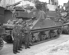 men in uniform standing next to tanks on the street