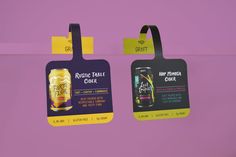 two plastic tags hanging from the side of a purple wall with yellow and black labels on them