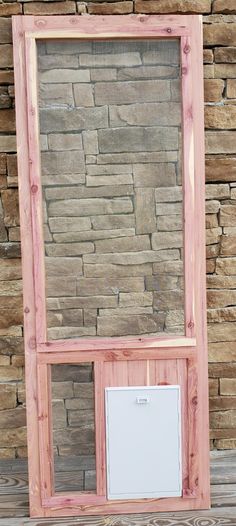 a wooden frame sitting on top of a table next to a brick wall and window