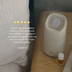 an air purifier sitting on top of a bed next to a night stand