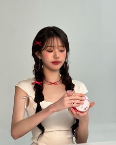 a woman in white dress holding a pink object