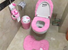 a bathroom with hello kitty rugs and pink toilet