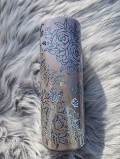 a blue and silver vase sitting on top of a fur covered floor next to a white rug