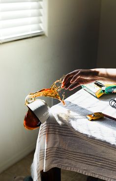 a person is pouring sauce onto a table