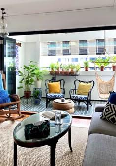 a living room filled with furniture and plants