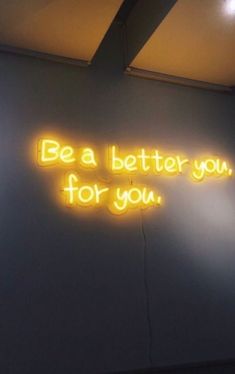 a neon sign that says be a better you for you on the wall in an office