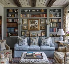 a living room filled with lots of furniture and bookshelves covered in pictures on the wall