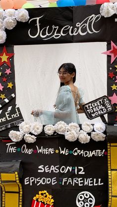 a woman standing in front of a black and white sign with flowers on it's side